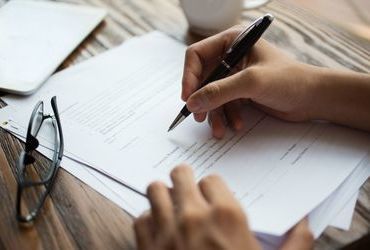 businessman-examining-papers-table.jpg